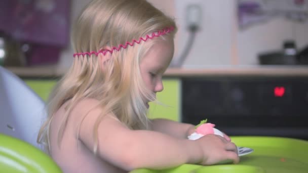 Child eating a cupcake in the kitchen, slow motion. — Stock Video