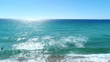 Güzel berrak deniz ve güneşli plaj. Tropikal şemsiyeler ve sahil beldesi.