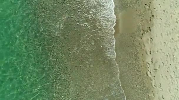 Havadan görünüm: sakin berrak deniz ve güneşli plaj. — Stok video