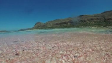 Tropik plaj, pembe kum ve berrak deniz. Sakin deniz dalgası.