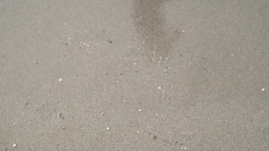 Yavaş çekim, deniz dalgaları kumlu kıyıyı yıkar. Deniz plajı arka plan.