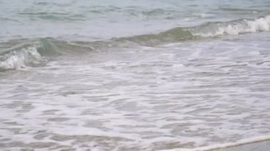 Yavaş çekim, deniz dalgaları ve kumlu plaj.