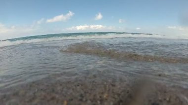 Yavaş çekim: kıyıda su sıçrayan deniz dalgası.