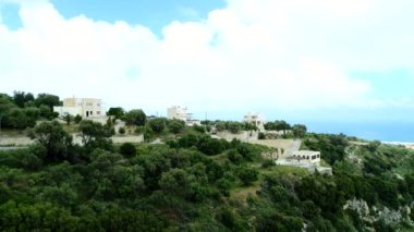 Havadan görünüm: yeşil orman, tepeler ve dağdaki evler.