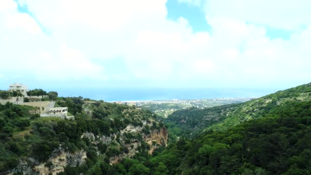 Vue aérienne : montagnes verdoyantes, forêt et maison sur la montagne .