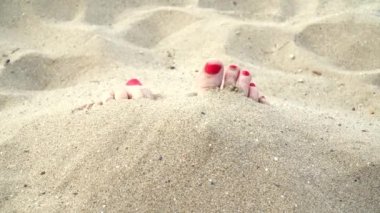 Sahilde kumda kadın ayakları, yakın çekim.