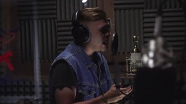 Kayıt stüdyosunda mikrofonerkek şarkıcı rap.