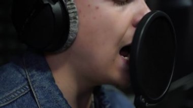 Bir adam mikrofona yakın çekim şarkı lar.