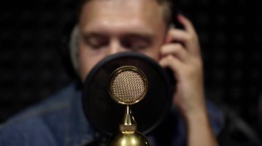 Mikrofon yakın çekim, kayıt stüdyosu, bir adam şarkı.