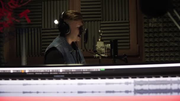 Ένας άντρας γράφει ένα τραγούδι σε ένα επαγγελματικό στούντιο ηχογράφησης.. — Αρχείο Βίντεο