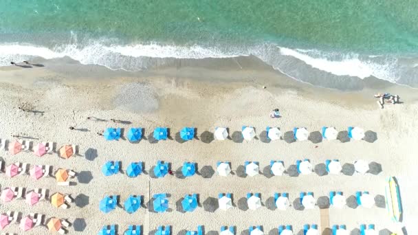 Θάλασσα και αμμώδης παραλία, θέρετρο, ομπρέλες, θέα στον αέρα. — Αρχείο Βίντεο