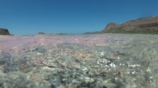 Gyönyörű tenger hátterében. Tengeri hullám, surf rózsaszín homok, víz alatti videó. — Stock videók