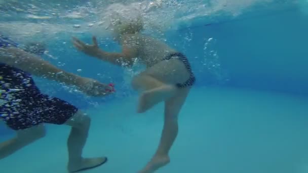 Bir çocuk yüzmek için havuzda bir eğitmen ile yüzmeyi öğrenir. — Stok video