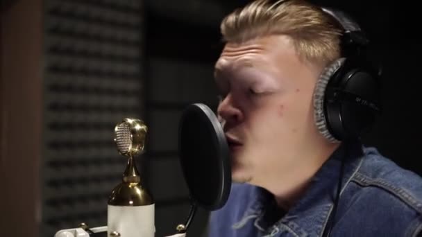 Мужчина поет в микрофон в студии звукозаписи . — стоковое видео