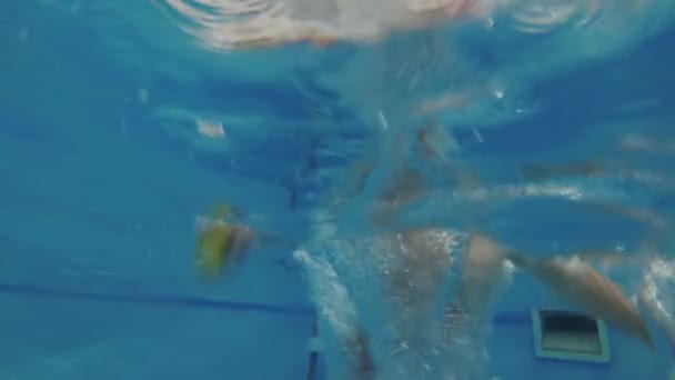 Un petit enfant plonge et nage dans la piscine sous l'eau . — Video