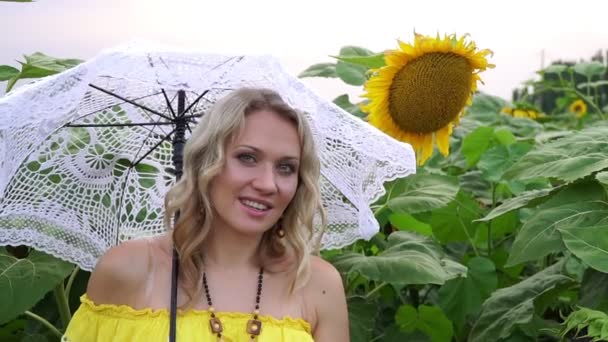 Porträt einer jungen Frau in einem Sonnenblumenfeld. Zeitlupe. — Stockvideo