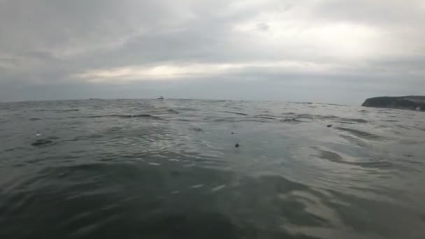 Regendruppels vallen in zee in het water. Donkere zee, bewolkt weer, wolken. — Stockvideo