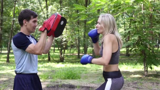 Młoda piękna kobieta praktykuje boks. Kobieta boks z instruktorem. — Wideo stockowe