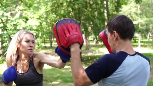 Jonge mooie vrouw is boksen in het Park. Boksen training, womens zelfverdediging. — Stockvideo