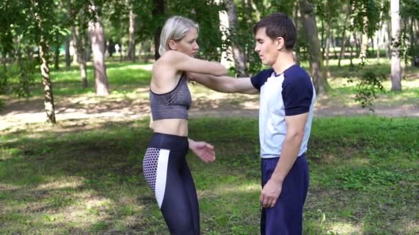 Belle femme apprend les techniques de lutte et d'auto-défense avec un entraîneur . — Video