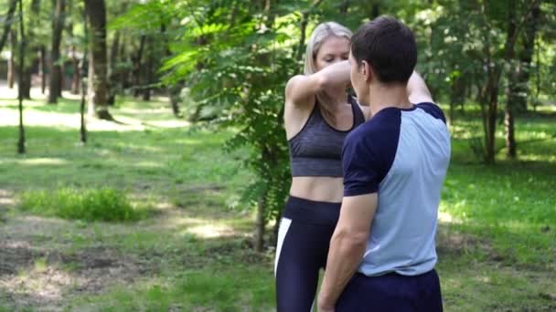 Una mujer hermosa aprende artes marciales y técnicas de lucha con un instructor . — Vídeos de Stock