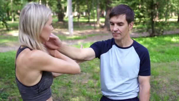 Mooie vrouw gaat in voor sport in het park met een trainer. — Stockvideo
