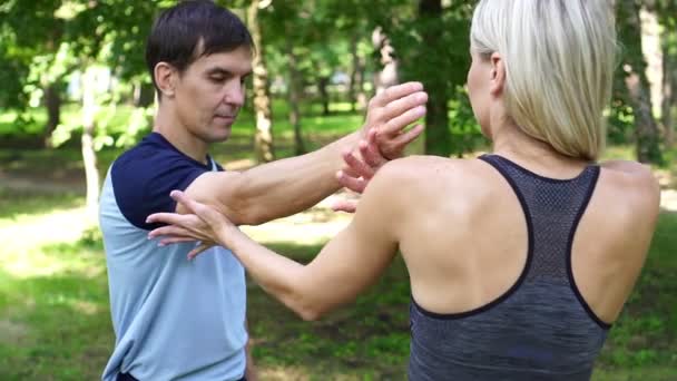 Jovem mulher está envolvida em fitness e luta livre no parque . — Vídeo de Stock