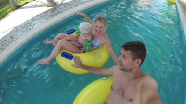 Mladá rodina s dítětem v bazénu na vodním parku. — Stock video
