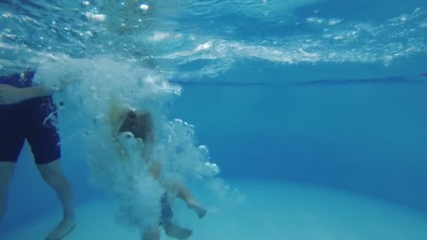 Entrenador enseña al niño a nadar en la piscina . — Vídeos de Stock