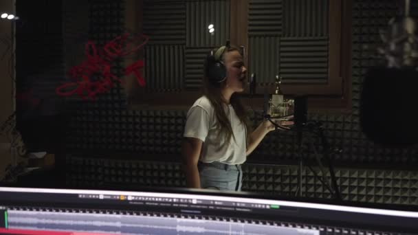 Studio di registrazione, una giovane cantante sta registrando una canzone . — Video Stock