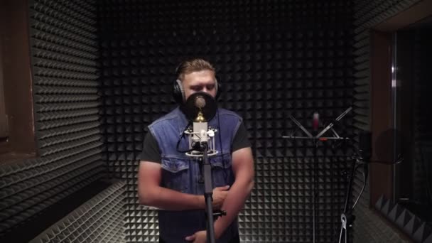 録音スタジオで男がマイクに歌い歌を録音する. — ストック動画