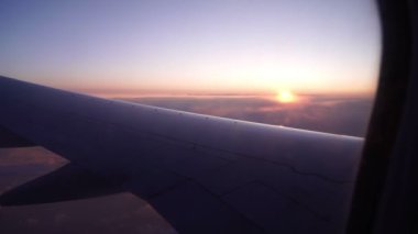 Uçak kanadı, pencereden şafağın arka planına bakın..