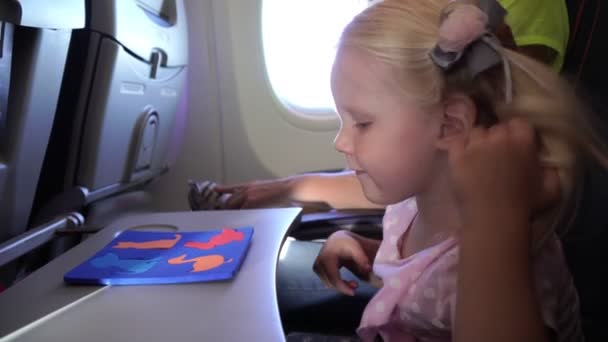 Girl child with mom fly in an airplane. — Stock Video