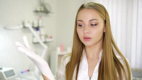 Mooie jonge vrouw arts, tandarts of cosmetoloog in een kliniek. — Stockvideo