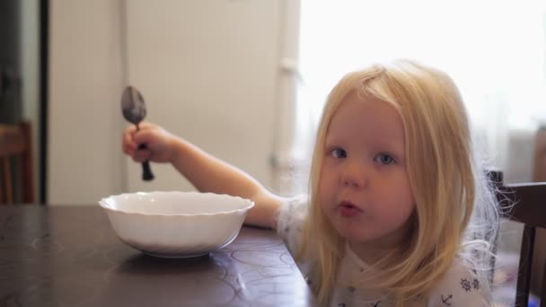 Дитяча дівчина поснідала на кухні з шоколадними кульками з молоком . — стокове відео