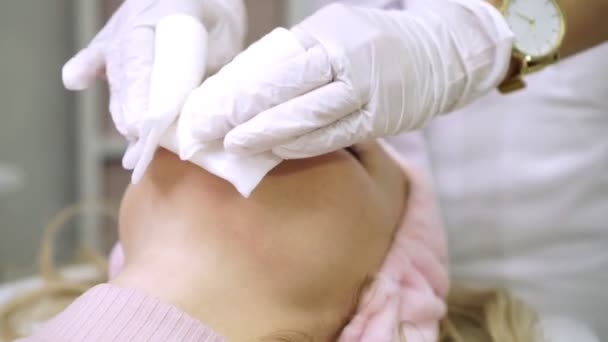 Salón de belleza, una mujer en la oficina de esteticistas durante un peeling facial . — Vídeos de Stock