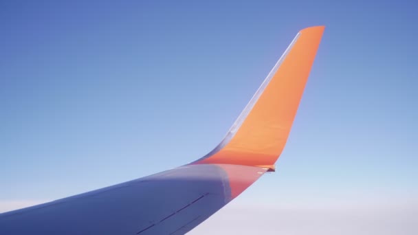 El ala de un avión de pasajeros contra un cielo azul . — Vídeo de stock