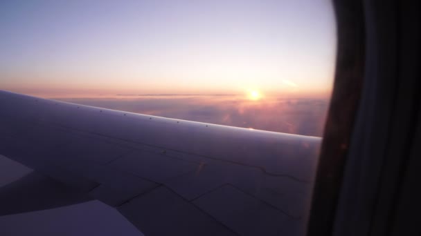Uçak penceresinden güzel manzara: şafak ya da gün batımı, güneş ışınları, uçağın kanadı.. — Stok video