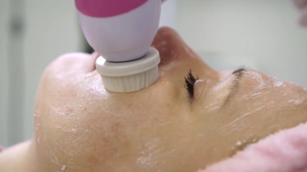 Mujer durante la limpieza facial por un esteticista. Joven mujer hace peeling en un salón de belleza . — Vídeos de Stock