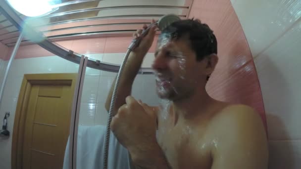 Un hombre se lava en la ducha y canta . — Vídeo de stock