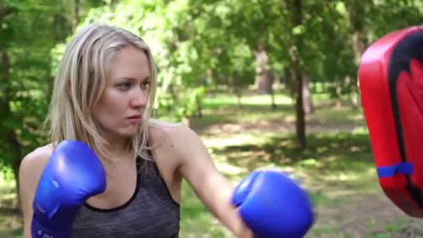 Kvinnlig boxare tränar i parken med tränare. — Stockvideo