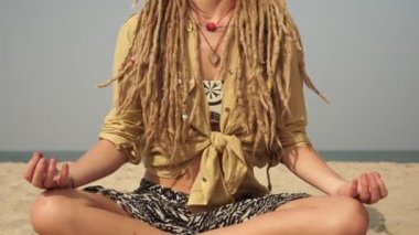 Rastalı güzel bir kadın yoga yapıyor ve meditasyon yapıyor.