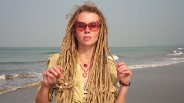 Портрет девушки-хипстера с дредами на фоне моря — стоковое видео