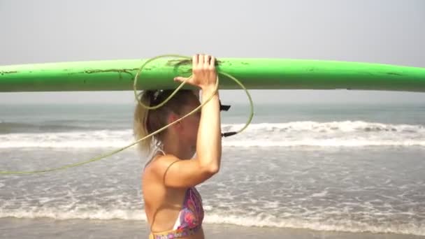 Retrato de uma mulher com prancha de surf. Menina surfista bonita na praia — Vídeo de Stock