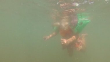 Çocuk yüzer denizde maske ve kol dalgalarıyla