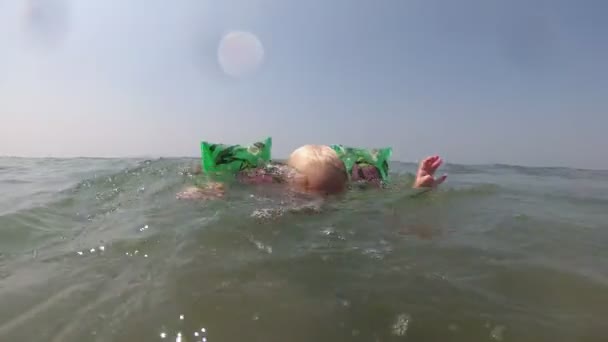 Kleines Mädchen lernt mit Brille und Rüschen schwimmen im Meer — Stockvideo