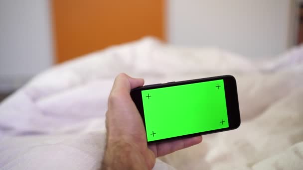 Руки держат смартфон с зеленым экраном для добавления контента — стоковое видео
