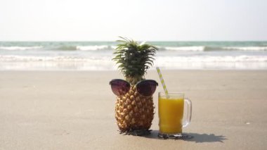 Deniz sahilinde dinlenen güneş gözlüklü turist ananası.