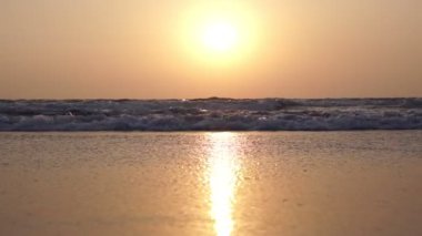 Denizin ve kumsalın üzerinde güzel altın gün batımı. Akşam deniz arkası.