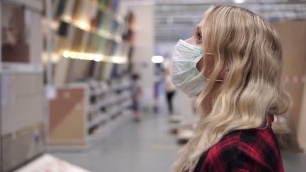 Retrato de mujer compradora en máscara médica en un gran supermercado — Vídeos de Stock